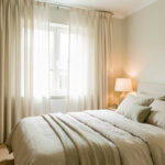 Les 7 équipements pour une chambre propice au sommeil Chambre lumineuse et apaisante avec un lit soigneusement fait, des rideaux épais, une lampe douce et des rangements discrets dans une ambiance naturelle.